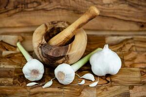 fresh Garlic for garlicoil on olive wood photo