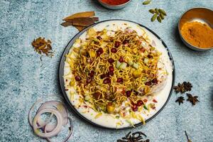 Papricha chotpoti with pomegranate seeds served in a dish isolated on grey background top view of bangladesh food photo