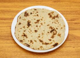 Simple tandoori roti served in plate isolated on table top view of indian and pakistani spicy food photo