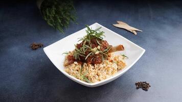 meat lamb vermicelli rice in rose mary sauce served in dish isolated on table top view of arabic food photo