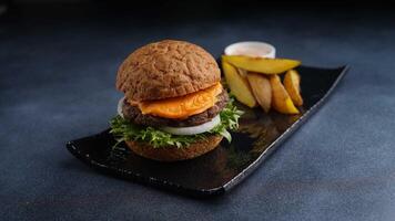 law fat beef petty burger with fatfree cheese with backed potato wedges and special sauce and ketchup on the side served in dish isolated on table top view of arabic food photo