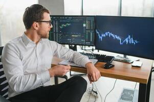 Serious business man trader analyst looking at computer monitor, investor broker analyzing indexes, financial chart trading online investment data on cryptocurrency stock market graph on pc screen. photo