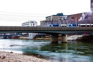 Salsburgo, Austria - 13.01.2024 eléctrico trenes viaje a través de el puente eisenbahnbrücke en Salsburgo. foto