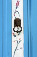 Blue Door with Iron Handle and Floral Painting. Adatepe, Turkey - August 21, 2023 photo