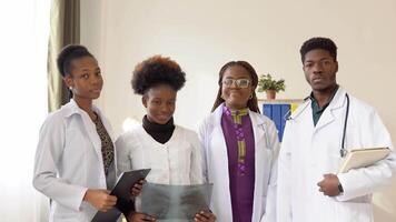 retrato do africano americano médico equipe em pé dentro moderno hospital. grupo do jovem africano alunos às a clínica video