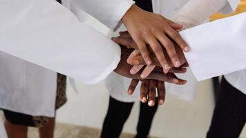 A team of doctors, including women and men of different nationalities, make a gesture of unity. Close-up shooting of hands video