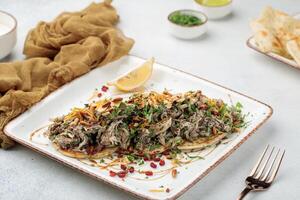 Musakhan chicken with lime served in dish isolated on table top view of arabian food photo