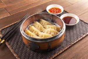 Bamboo Steamed Pork Dumplings with sauce served dish isolated on wooden table top view of Hong Kong food photo