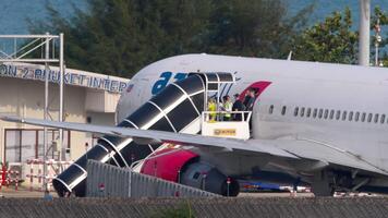 PHUKET, THAILAND - FEBRUARY 26, 2023. Passengers leave the Boeing 767-3Y0, ER, RA-73080 of Azur Air at Phuket airport , HKT through a mobile stairway. Group of people disembarking the airplane video