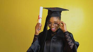 A joyful graduate student holds an international diploma and plays with her glasses and expresses happiness and positive emotions about her achievement. Doctor of Philosophy video