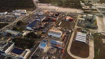 Large coal fired power station in with coal stack and biomass storage tanks for net zero electricity generation and future carbon capture capabilities. Drone camera is orbiting around the factory. video