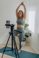 A 50-year-old woman doing online yoga at home photo