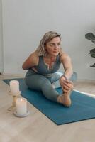 A 50-year-old woman does yoga at home photo