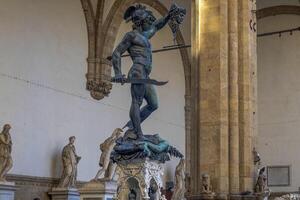 Detail of Perseus holding head of Medusa, bronze statue in Loggia de Lanzi, Piazza della Signoria, Florence, Italy. Isolated on white photo