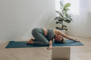 A 50-year-old woman does yoga at home photo