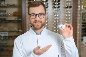 Doctor holds in his hand container with soft contact lenses for single use. Ophthalmologist prescribes use of one-day contact lenses for vision correction. Myopia and eyesight problem concept. photo