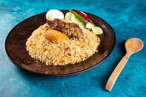 spicy beef pulao, polao, biryani, mandi, kacchi with egg and salad served in dish isolated on table top view of indian food photo