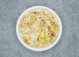 Mixed cream fruit chaat masals with banana, apple pineapple, dates, pomegranate seeds served in dish top view of indian and pakistani food photo