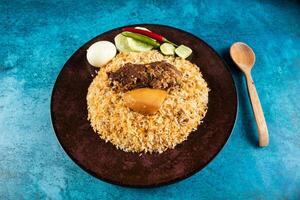 spicy beef pulao, polao, biryani, mandi, kacchi with egg and salad served in dish isolated on table top view of indian food photo