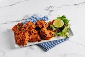 Lemon Chilli chicken Tikka Boti Kebab in a dish isolated on napkin side view on grey background famous indian and pakistani food photo