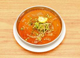 pollo o carne de vaca nihari con limón y jengibre rebanada servido en un plato aislado en de madera mesa lado ver de indio, pakistaní comida foto