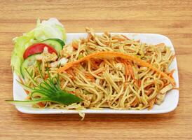 2376311 pollo chowmien con ensalada servido en un plato aislado en gris antecedentes lado ver de indio, pakistaní comida foto