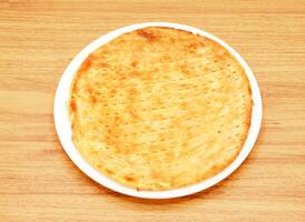 translúcido taftán, naan o kulcha, Roti servido en un plato aislado en de madera mesa lado ver de indio, pakistaní comida foto