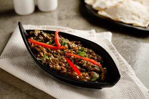 spicy meat liver masala served in a dish isolated on grey background side view fast food photo