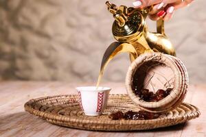 Arabic coffee with dates served with teapot in cup isolated on background top view ramadan food photo