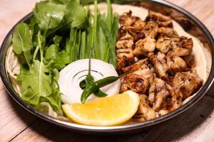 Chicken tikka Dajaj with salad, wedges, lemon and dip served in dish isolated on background top view of arabic food photo