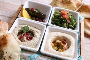 Classic mezza platter with Baba Ganoujm, Turkish Salsa, Labneh, Taboula and Vine leaves served in dish isolated on background top of arabic food cold mezza photo