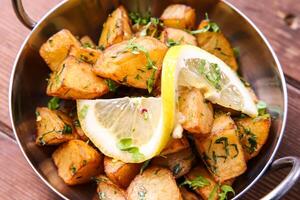Batata Harra or lebanese spicy potatoes with lemon served in dish isolated on background top view of hot mezza photo