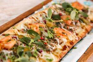 Sujuk with jibin pizza bread served in wooden board isolated on background top view of Arabic Manaqeesh photo