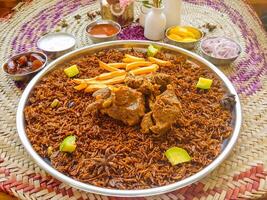 Machboos lamb or biryani, mandi, kabsah and raita served in dish isolated on table top view of arab food photo