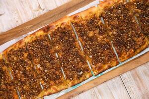 Zaatar pizza bread served in wooden board isolated on background top view of Arabic Manaqeesh photo