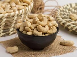 fresh cashewnut served in a bowl isolated on napkin side view of nuts on grey background photo