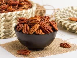 nuez pecana servido en un cuenco aislado en servilleta lado ver de nueces en gris antecedentes foto