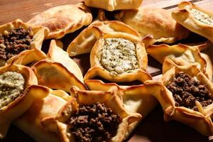 Assorted Mixed Fatayer with Labneh, Zataar, Mortadella, jibin, Mozzarella, Rahash, chocolate, Sabanikh and sujuk baked isolated background top view arabic food photo