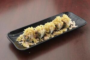 kasu maki served in a dish isolated on wooden table background side view of singapore food photo