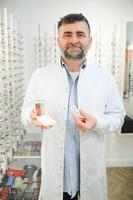 Doctor holds in his hand container with soft contact lenses for single use. Ophthalmologist prescribes use of one-day contact lenses for vision correction. Myopia and eyesight problem concept. photo