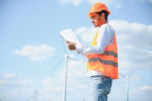 indio ingeniero en pie en contra molinos de viento foto