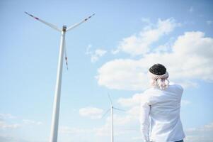 Indian Engeenier standing against windmills photo