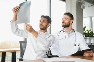 An Indian doctor and a European doctor stand together in a hospital lobby photo