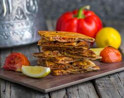 Spicy arrayes served in wooden board side view on wooden table background photo