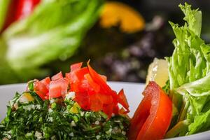 TABOULA or tabouleh salad with tomato and leaves served in dish close up side view of arab food photo