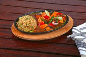 Salmon Sizzling With Brown Fried Rice served in dish isolated on table side view of middle east food photo