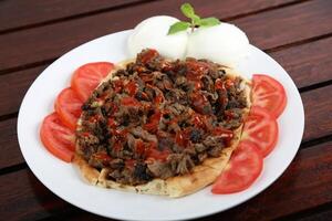 iskander kabab con un pan y tomate rebanada servido en un plato aislado en mesa lado ver de medio este comida foto