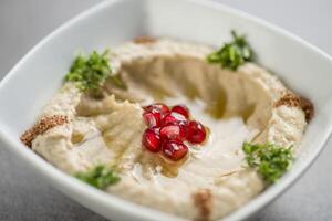 mutabel with pomegranate seeds served in dish isolated on grey background top view of arabic food photo