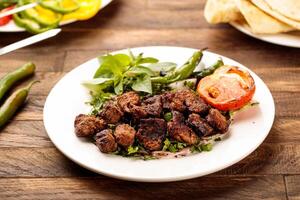 Beef Grill Tikka boti kabab with tomato, salad and bread served in a dish isolated on wooden table background side view of fastfood photo
