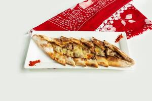 Turkish style Pide in a dish isolated on colorful table cloth top view on grey background in a dish isolated on colorful table cloth top view on grey background photo